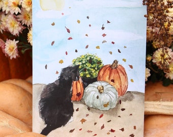 Puede incluir: Una pintura de acuarela de un gato negro sentado junto a tres calabazas. Las calabazas son naranja, blanca y verde. El fondo es un cielo azul claro con hojas que caen.