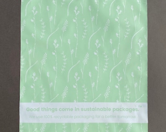 May include: A green mailing envelope with a white floral pattern. The envelope has a white label with the text "Good things come in sustainable packages. We use 100% recyclable packaging for a better tomorrow. TM"