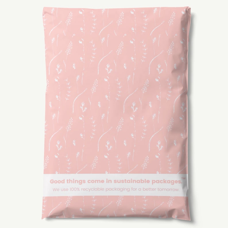 K&ouml;nnte beinhalten: Rosafarbener Poly-Versandbeutel mit wei&szlig;em Blumenmuster. Der Beutel hat ein wei&szlig;es Etikett mit dem Text "Good things come in sustainable packages. We use 100% recyclable packaging for a better tomorrow. TM"