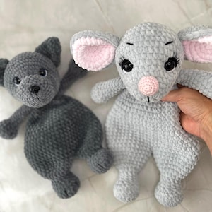May include: Two handmade crochet plush toys. One is a dark charcoal gray bear with black eyes and a black nose. The other is a light gray mouse with large ears featuring pink inner accents, a pink nose, and long black eyelashes on its dark eyes.