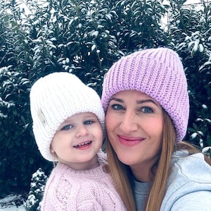 May include: A white ceramic mug with a black handle and the text "But First, Coffee" in a bold, black font. The mug is set against a neutral background, highlighting its simple design.