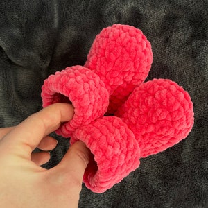 May include: Four pink fuzzy crocheted slippers. The slippers are made with a soft, textured yarn.