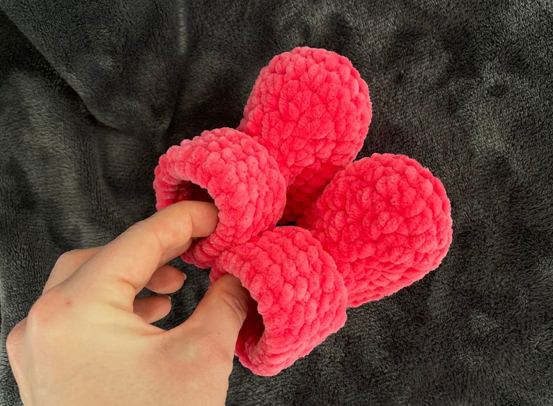 May include: Four pink fuzzy crocheted slippers. The slippers are made with a soft, textured yarn.