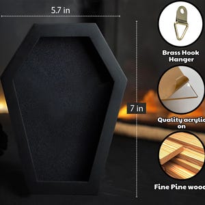 Puede incluir: Una vitrina negra en forma de ata&uacute;d, de 14,5 cm de ancho y 17,8 cm de alto, con interior texturizado. Incluye un colgador de gancho de lat&oacute;n, acr&iacute;lico de calidad y madera de pino fina.