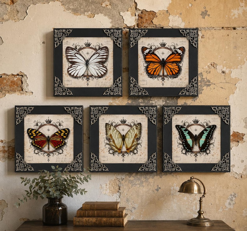 May include: Five square wall art pieces featuring butterfly illustrations centered within ornate circular frames and crowns. Each black frame has decorative silver-toned metal corner accents. The butterflies display white, orange, red, yellow, and teal colors.