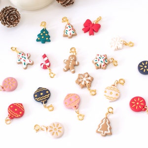 May include: A collection of 17 Christmas-themed charms, including gingerbread men, candy canes, ornaments, snowflakes, and Christmas trees. The charms are made of polymer clay and have a gold-colored metal loop for attaching to a bracelet or necklace.