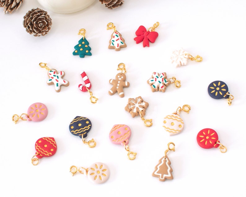 May include: A collection of 17 Christmas-themed charms, including gingerbread men, candy canes, ornaments, snowflakes, and Christmas trees. The charms are made of polymer clay and have a gold-colored metal loop for attaching to a bracelet or necklace.