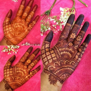 May include: Close-up of two hands with intricate henna designs. The henna is a deep brown color and covers the entire palm and fingers. The designs are symmetrical and include floral and geometric patterns.