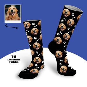 May include: Black socks with a repeating pattern of a golden retriever's face, white paw prints, and bones. The image includes a small photo of the dog and text that reads "1-8 DIFFERENT FACES".