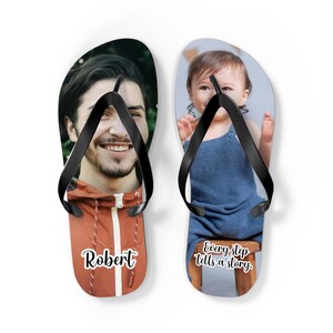 May include: A pair of custom flip-flops with black straps. The left sandal features a photograph of a man in an orange jacket with the name Robert printed below. The right sandal displays a photograph of a child with the text Every step tells a story.