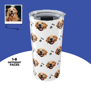 May include: A white travel tumbler featuring a repeating pattern of smiling golden retriever faces, paw prints, and bones. The tumbler has a clear lid and a black slider. The text "1-8 DIFFERENT FACES" is on the side.