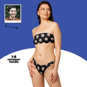 Puede incluir: Conjunto de bikini negro de dos piezas con un patrón repetido de caras sonrientes. El top es sin tirantes y la parte inferior es de talle bajo. La imagen también incluye una pequeña foto de un rostro masculino y el texto "1-8 DIFFERENT FACES".