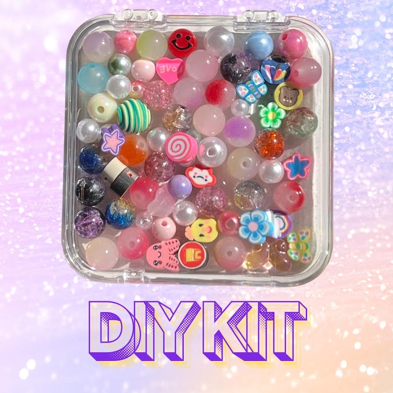May include: A clear plastic container filled with colourful beads. The beads are various shapes and sizes, including stars, hearts, and smiley faces. The container is labelled "DIY KIT".