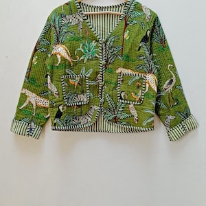 Könnte beinhalten: Eine grüne gesteppte Jacke mit Dschungelprint mit Zebras, Leoparden, Tukanen und Palmen. Die Jacke hat einen V-Ausschnitt und einen Knopfverschluss.