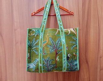 May include: A green tote bag with a white and green trim. The bag features a tropical print with palm trees, birds, and zebras.