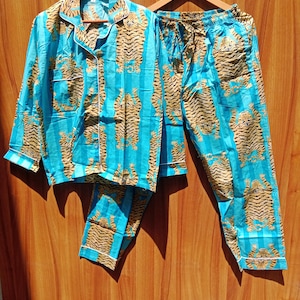 May include: A blue and brown pajama set with a tiger print. The top has a button-up front and long sleeves. The pants have an elastic waistband and a drawstring.