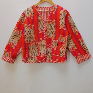 May include: A red and pink quilted jacket with a tiger print and striped details. The jacket has a button closure and two pockets.