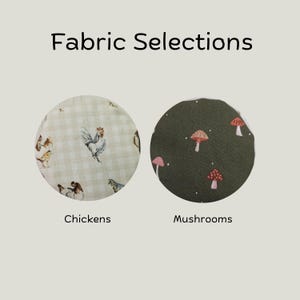May include: Fabric Selections text above two circular fabric swatches. The left swatch features a beige gingham pattern with illustrations of chickens. The right swatch is dark olive green with a pattern of small red and white mushrooms.