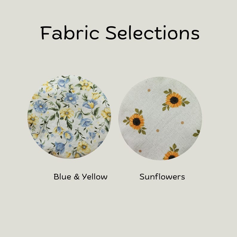 May include: Fabric Selections text above two circular fabric swatches. The left swatch features a dense pattern of blue and yellow flowers with green leaves. The right swatch displays a light background with sunflowers and small brown dots.