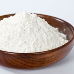 May include: A close-up of a wooden bowl filled with white flour.