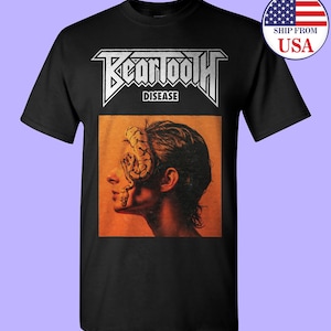May include: Black t-shirt with a white graphic of the band Beartooth. The graphic features the band's name in bold white letters with the word "Disease" underneath. The graphic also features a close-up of a person's face with a snake wrapped around their head.