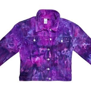K&ouml;nnte beinhalten: Eine lilafarbene Batik-Jeansjacke mit Knopfleiste und zwei Taschen auf der Vorderseite.
