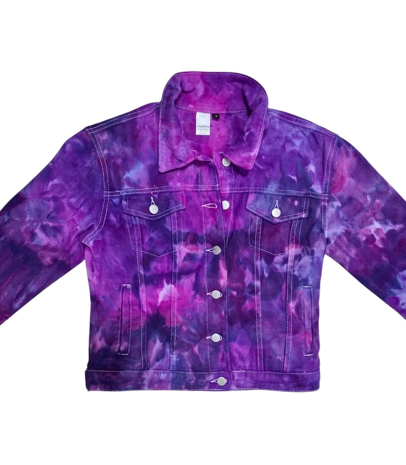 K&ouml;nnte beinhalten: Eine lilafarbene Batik-Jeansjacke mit Knopfleiste und zwei Taschen auf der Vorderseite.