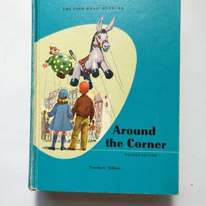 May include: A vintage book titled "Around the Corner" with a teal cover. The cover features an illustration of a donkey, a clown, and two children. The text "The Ginn Basic Readers" and "Teachers' Edition" are also visible.