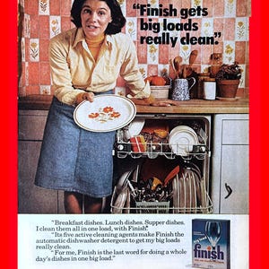 May include: Vintage advertisement featuring a woman holding a plate with orange floral designs. The ad promotes "Finish" dishwasher detergent, with text stating it cleans big loads. A dishwasher is open, filled with dishes.