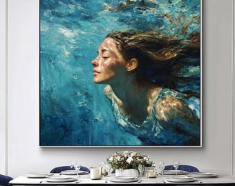 May include: A large framed painting depicts a woman underwater, her face serene, surrounded by swirling blue hues. The artwork, with its textured brushstrokes, evokes a sense of depth and tranquility. The painting is displayed above a dining table with blue chairs.