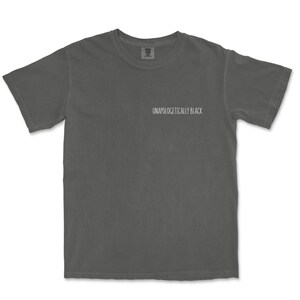 May include: A charcoal gray t-shirt with the text "Unapologetically Black" printed on the front.