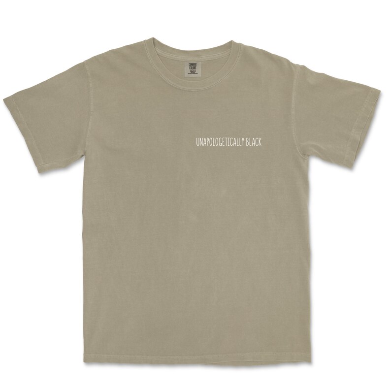 May include: A light gray t-shirt with the text "Unapologetically Black" printed on the front.