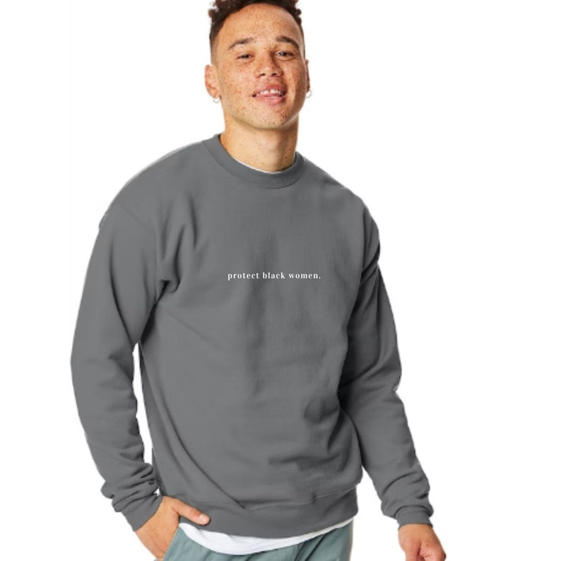 May include: A charcoal gray sweatshirt with the text "protect black women." printed in white on the front.