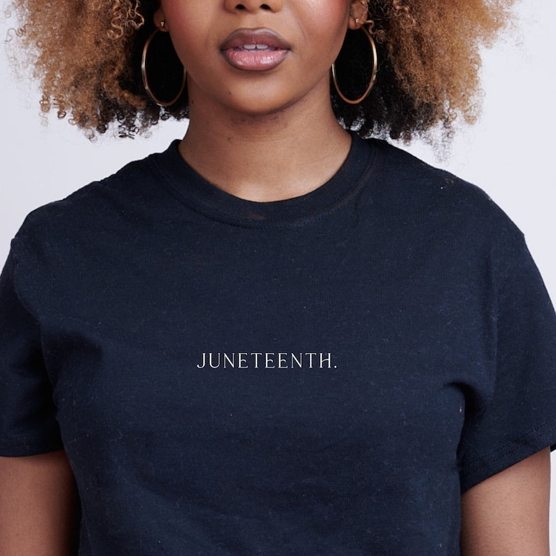 K&ouml;nnte beinhalten: Ein schwarzes T-Shirt mit dem Text "JUNETEENTH." in wei&szlig; auf der Vorderseite.