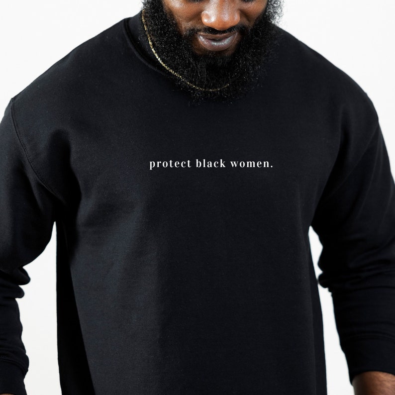 May include: A black long-sleeved sweatshirt with the text "protect black women." printed in white on the front.