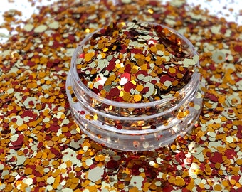 May include: A clear plastic jar filled with gold, red, and orange glitter. The glitter is in various shapes and sizes.