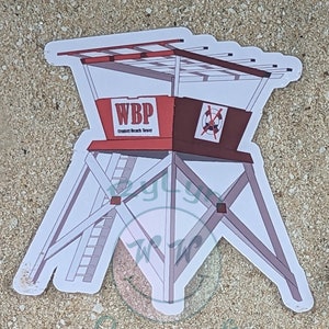 Pode incluir: Um adesivo branco de uma torre de salva-vidas vermelha e marrom com o texto "WBP Crescent Beach Tower" na frente. A torre tem uma escada branca e um telhado branco.