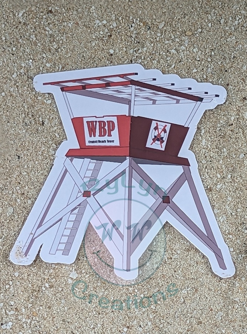 Pode incluir: Um adesivo branco de uma torre de salva-vidas vermelha e marrom com o texto "WBP Crescent Beach Tower" na frente. A torre tem uma escada branca e um telhado branco.