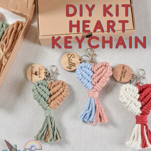 May include: DIY kit to make a heart-shaped keychain. The kit includes colorful string, wooden beads, and a metal ring. The finished keychain is shown in three different colors: green and brown, blue and pink, and white and red.