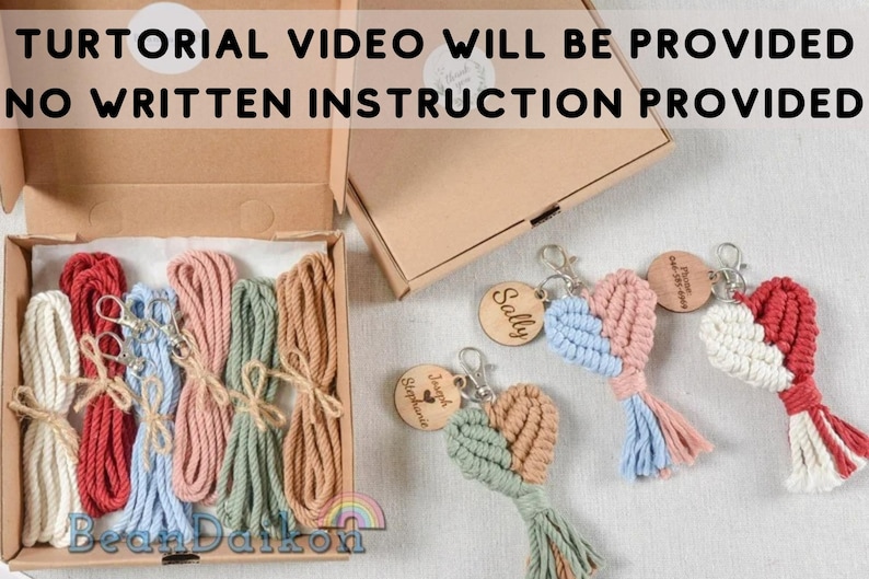 May include: A kit for making macrame heart keychains. The kit includes five spools of colorful string, five metal key rings, and five wooden tags with names. The kit is packaged in a brown cardboard box.  The text "TUTORIAL VIDEO WILL BE PROVIDED NO WRITTEN INSTRUCTION PROVIDED" is printed on the box.