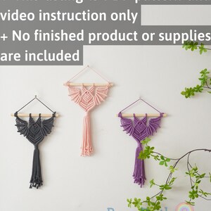 May include: Three macrame wall hangings in the shape of a bat with tassels. The hangings are in shades of grey, pink, and purple. The text "BeanDaikon beandaikon.etsy.com" is at the bottom of the image.