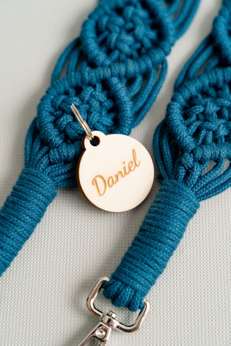 May include: A teal blue macrame dog leash with a wooden tag that says "Daniel" attached to it.