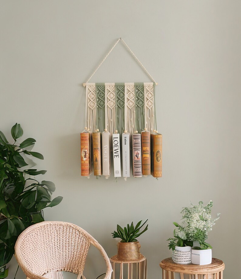 May include: A macrame wall hanging with a green and white pattern, holding a row of books. The books have titles like "LOEWE" and "Vogue".