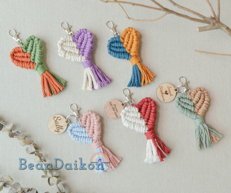 May include: A set of colorful heart-shaped keychains with tassels. Each keychain has a wooden tag with a name on it. The names on the tags are Sally, Joseph Stephanie, and  Princeton August 2023.