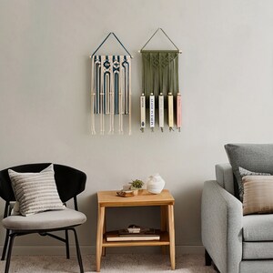 May include: Two macrame wall hangings, one blue and white, the other green, with books displayed on the green one.