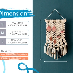 May include: A white macrame wall hanging with a triangular shape and fringe. It has a variety of jewelry items hanging from it, including earrings, necklaces, and bracelets. The wall hanging is 12 inches wide by 20 inches high, or 30 centimeters wide by 50 centimeters high. This item does not include any jewelry or props in the photos.