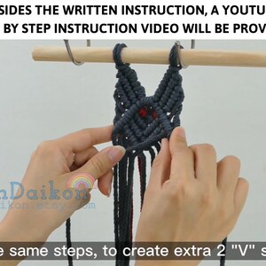 May include: A close-up of a hand holding a dark blue macrame wall hanging with red accents. The wall hanging is in the shape of a cat's face. The text "ean Daikon" and "eandaikon.etsy.com" is visible in the lower left corner of the image. The text "o the same steps, to create extra 2 "V" shape" is visible in the lower right corner of the image.