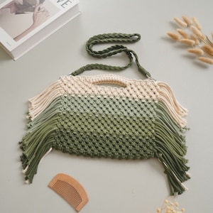 May include: A green, white, and cream crocheted bag with a long green strap and fringe details.