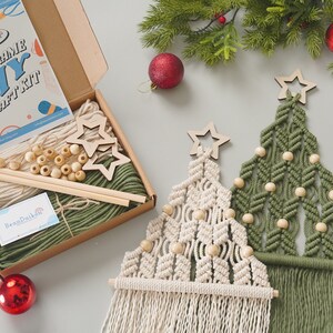 May include: A DIY macrame Christmas tree craft kit with two wooden stars, green and white yarn, wooden beads, and two wooden dowels. The kit comes in a brown box with a label that says "Macrame DIY Craft Kit".