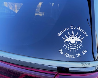May include: A white vinyl decal applied to a car rear window featuring a stylized eye graphic with radiating spikes and the text Return To Sender So Mote It Be arranged in a circular pattern around the central eye design.